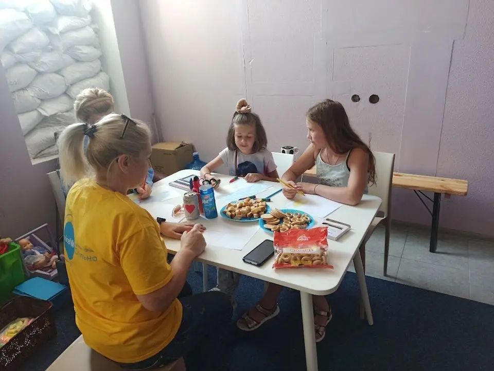 On June 6, 2023, children draw at a pop-up UNICEF Spilno center at the Kherson train station while waiting to be evacuated following the attack on the Kahkovka dam.