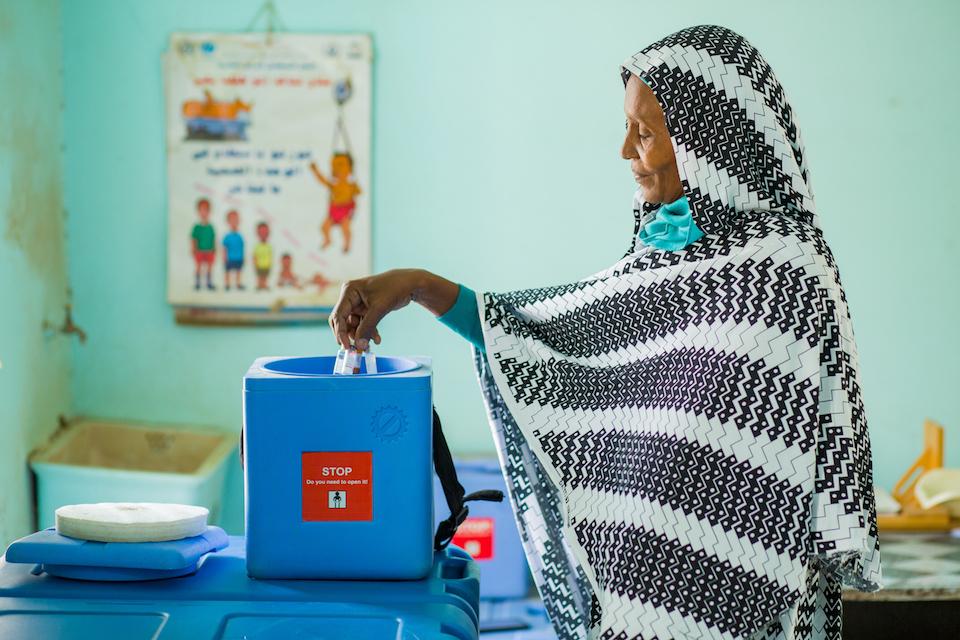 On June 5, 2023, Ibtisam Abdullah, a UNICEF-supported vaccinator at Gezirat Al-Feel Health Center in Sudan loads vaccines into a cooler box.