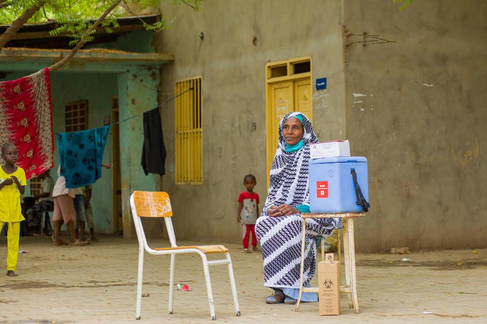 In Sudan on June 5, 2023, Ibtisam Abdullah, a vaccinator at Gezirat Al-Feel Health Center waits for mothers to bring their children for vaccination at a shelter for displaced people.