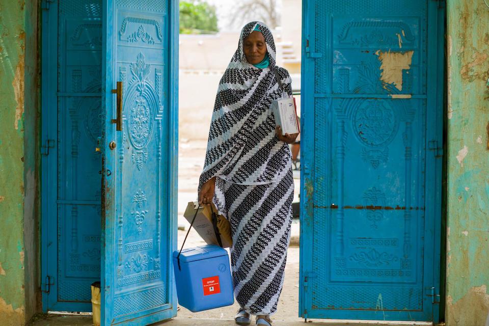 On June 5, 2023, Ibtisam Abdullah, a UNICEF-supported vaccinator at Gezirat Al-Feel Health Center in Sudan, arrives at a shelter for displaced people including children to provide vaccination services.
