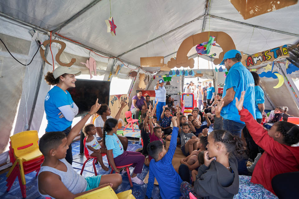 Migrant children participate in an activity with UNICEF Ambassador Laurie Hernandez in a Child- Friendly Space in Lajas Blancas, Darien, Panama.