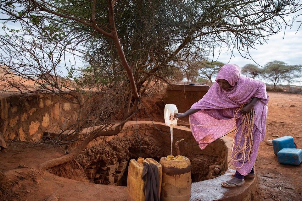 Naima, 14, of Ethiopia pours water from the village well into a jerry can, a chore she completes early in the morning to make time for school..