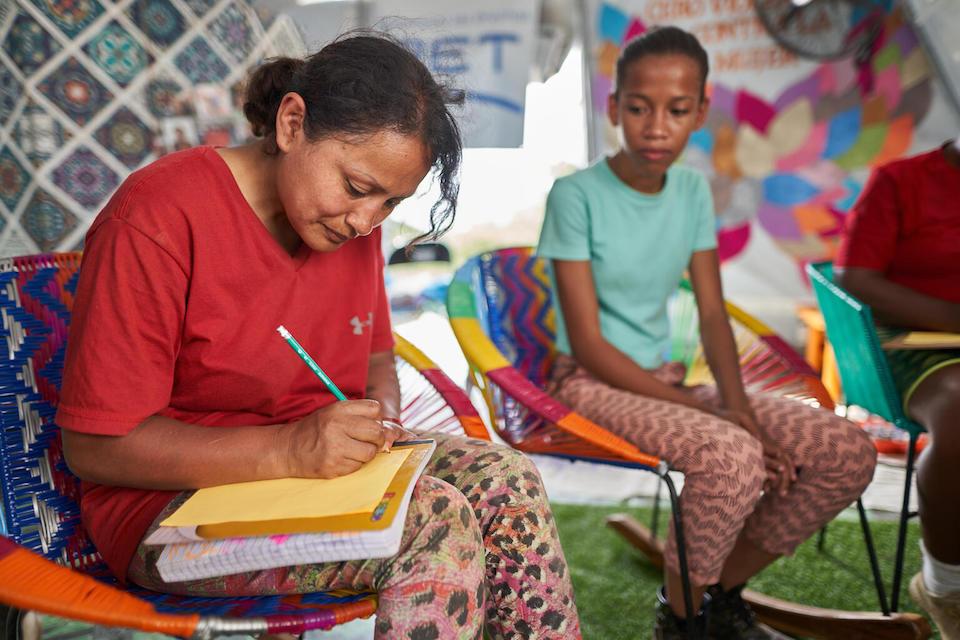 A migrant woman participates in the “Letters” workshop in the UNICEF Self-Care Space in Lajas Blancas, Darien, Panama.