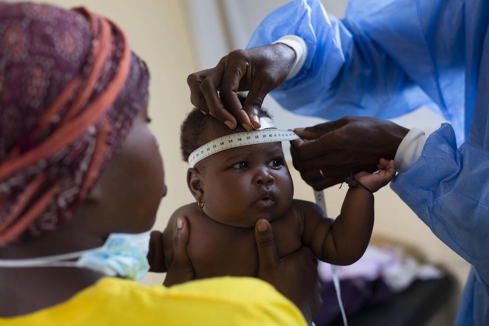 Four-month-old Nhairi Lwini is held by her mother, Fatima Domingos, while her measurements are taken during a medical checkup in Luanda, Angola.