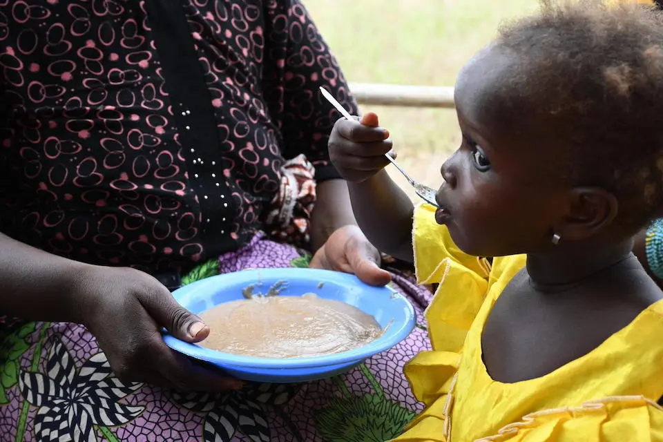 Children receive a nutritious meal after a cooking demonstration, in the village of Tiemekosso, northwest Côte d’Ivoire.