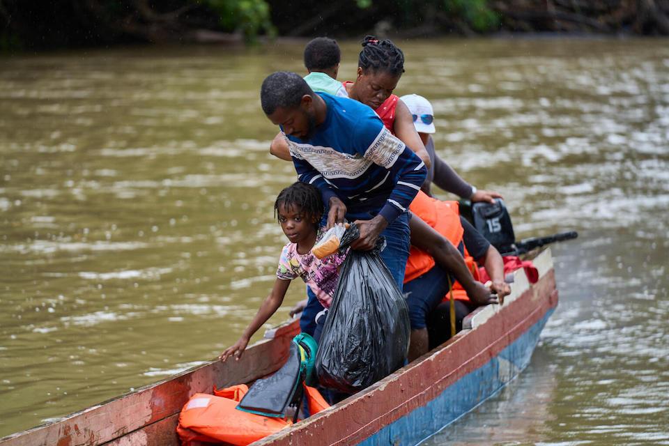 A Haitian family arrives by boat at the Lajas Blancas Temporary Migrant Reception Center, after crossing the Darién jungle.