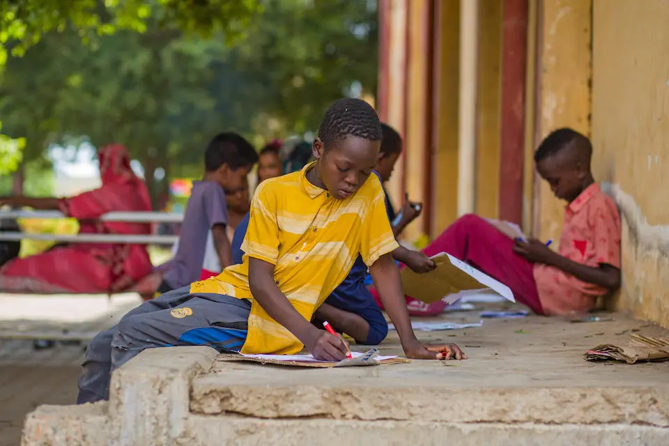 Qasim, far right, and other children express their feelings after being caught up in Sudan's ongoing conflict.