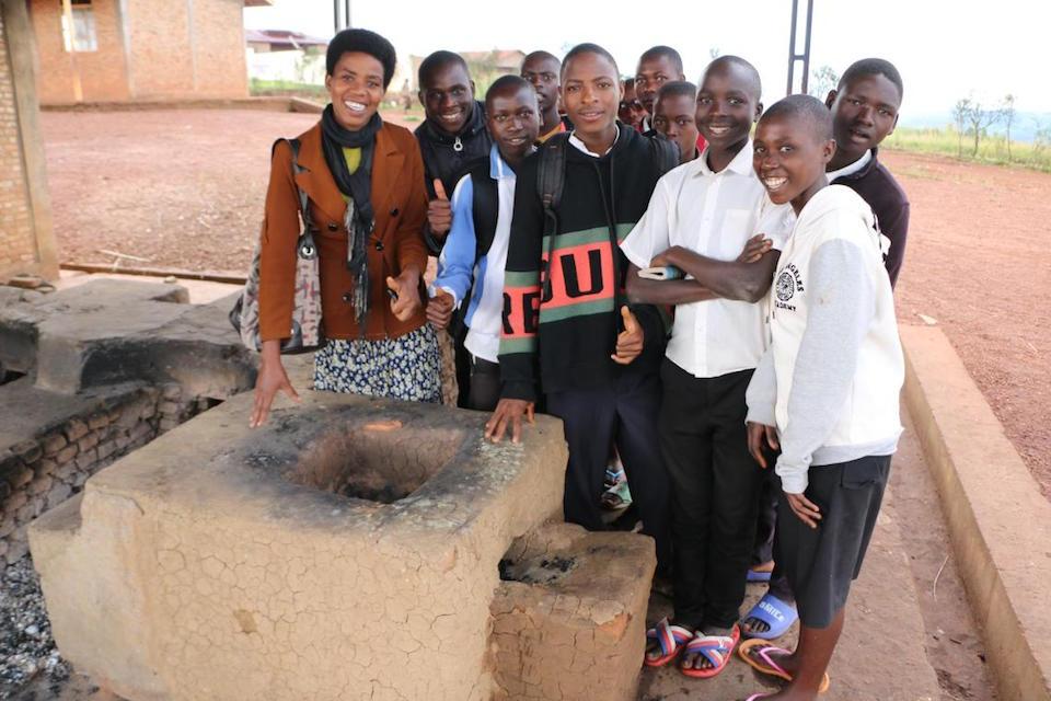 Teacher Isidonie Nzeyimana and her students show a large cookstove made in Communal Technical High School (LTC) in Muruta, Muyinga Province, Burundi.