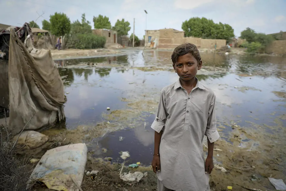 A boy stands in front of what remains of the family home in Rajar village, Mirpur Khas district, Sindh Province, Pakistan, destroyed in the 2022 floods.