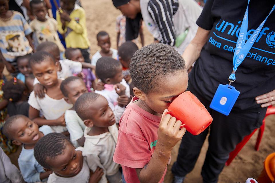 A boy from the Paquitequete community drinks a glass of rehydration serum as part of a demonstration session for the preparation of homemade rehydration, supported by UNICEF and partners.