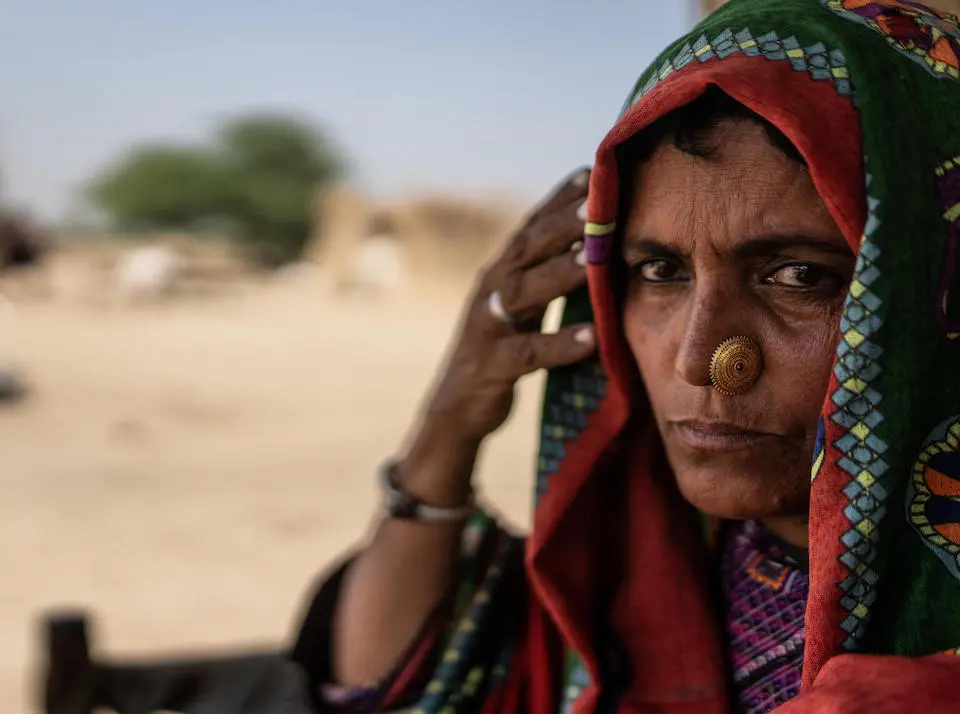 A mother in South Punjab, Pakistan, takes cover from the sun.