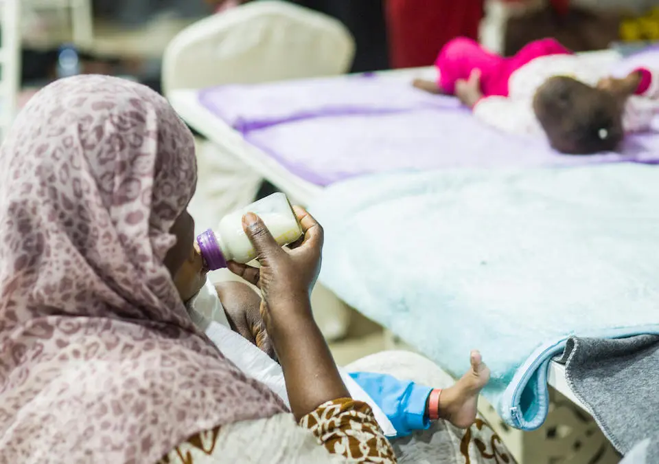On June 8, 2023, a woman gives therapeutic milk to a child who was relocated from the Mygoma orphanage in Khartoum, Sudan, with support from UNICEF.