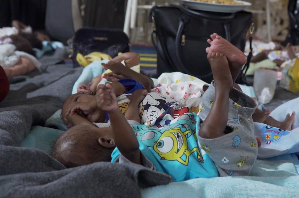 Young children relocated with UNICEF's help from a Khartoum orphanage lie on a blanket at the relocation facility.