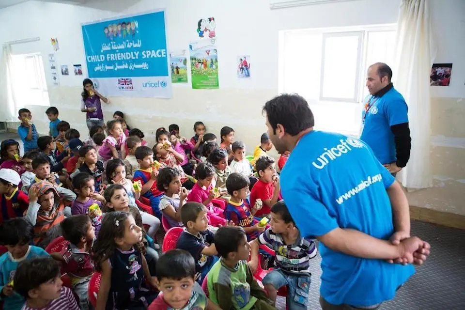 UNICEF staff engage children at a Child-Friendly Space in the Domiz refugee camp in Northern Iraq.