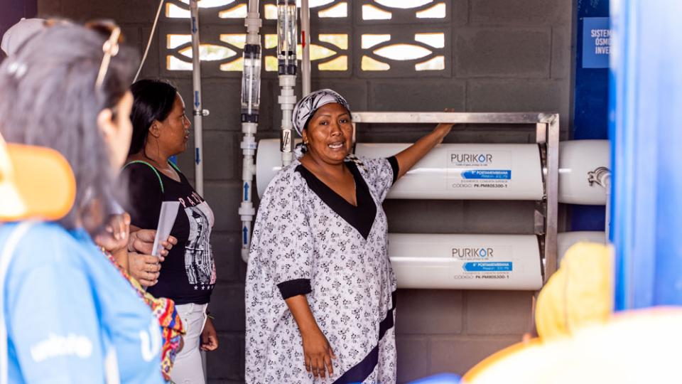 A member of the local community’s Water Committee shows off her knowledge of the reverse-osmosis filtration system providing sustainable water via the partnership project. Integrating local people into the project has been a key driver of the project’s success. ©UNICEF/Berger