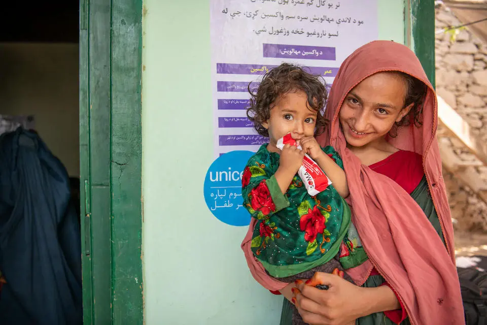 In Samsagal village, Nari district, Kunar province, Zarmina, left, who is being treated for severe acute malnutrition, consumes Ready-to-Use Therapeutic Food supplied by UNICEF.