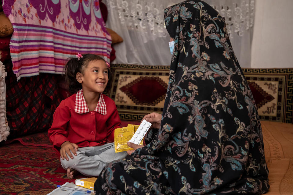 Anees Gul, age 5, is visited for a checkup by Community Health Worker (CHW) Rahima Karimi, who had referred the little girl for treatment for severe malnutrition when she was just 1.
