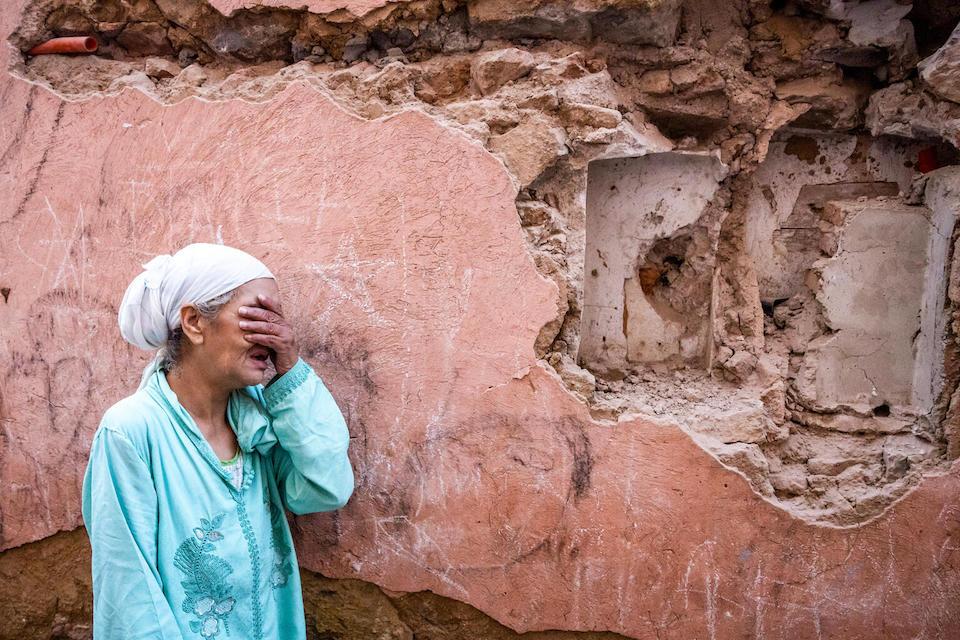 A woman reacts standing infront of her earthquake-damaged house in the old city in Marrakesh on September 9, 2023. 