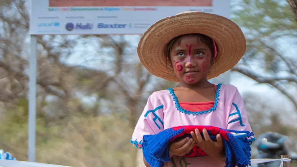 A Wayúu girl holds the scissors that will cut the tape that officially declares her community free of open defecation as of March 2023. @UNICEF/Josué Mejía