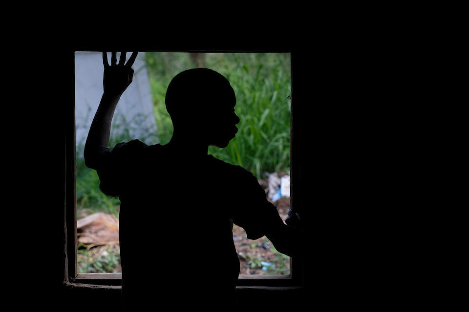 A boy who was abducted by an armed group in South Sudan looks out of a window of a UNICEF-supported child care center after being released. 