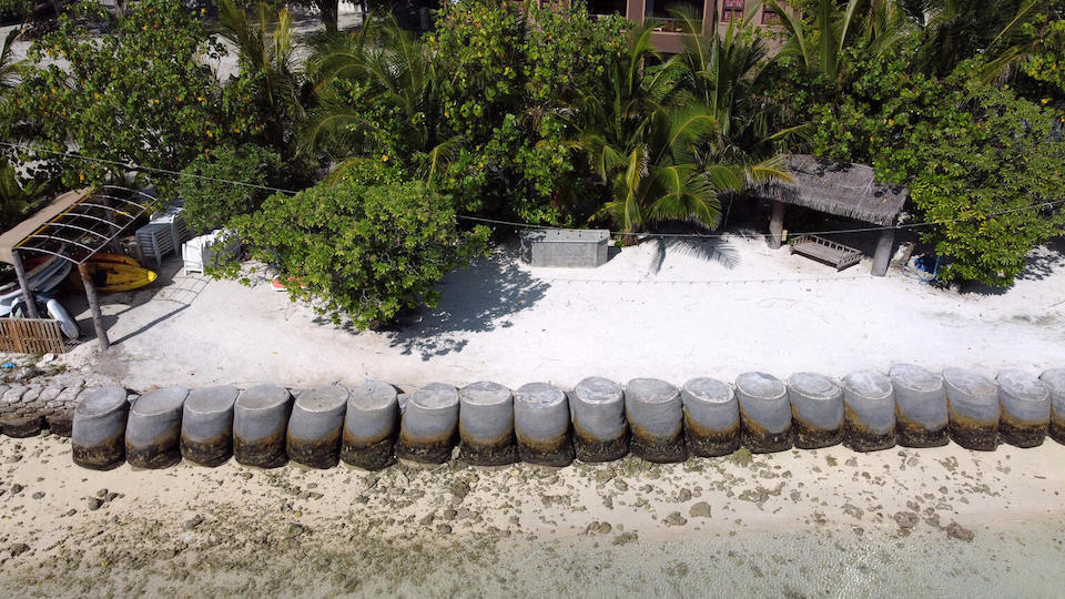 Concrete cylinders create a protective barrier along a low-lying beach in the Maldives, which faces coastal erosion and other threats due to climate change.