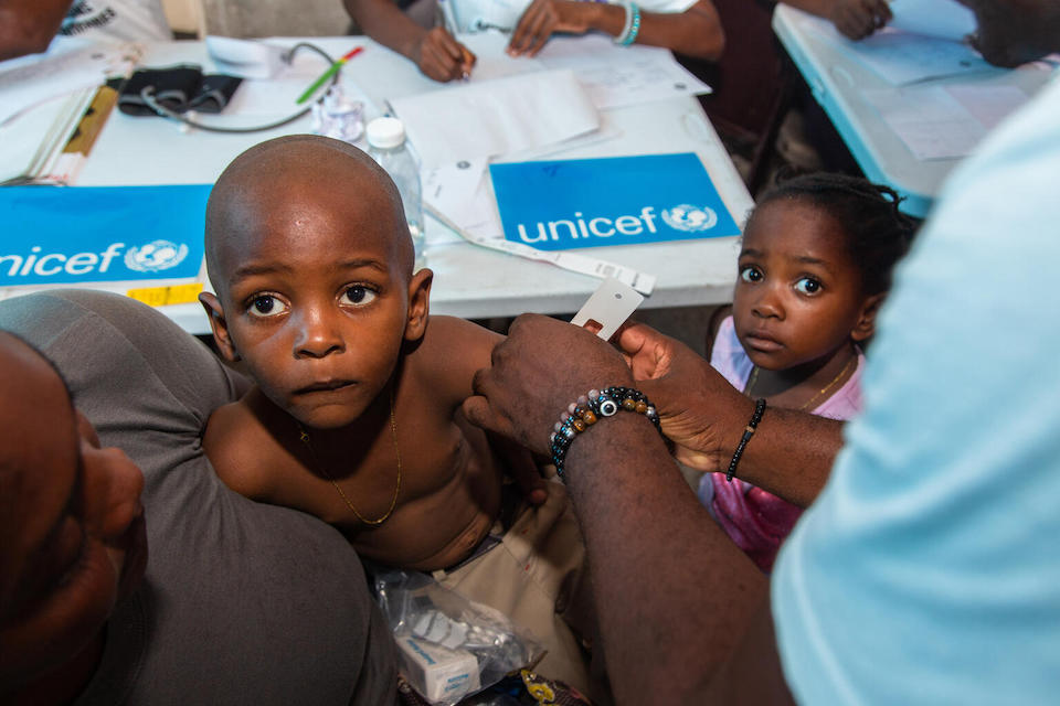 A child has his upper arm circumference measured to screen for malnutrition at a UNICEF-supported mobile health clinic at a camp for displaced families in Port-au-Prince, Haiti.