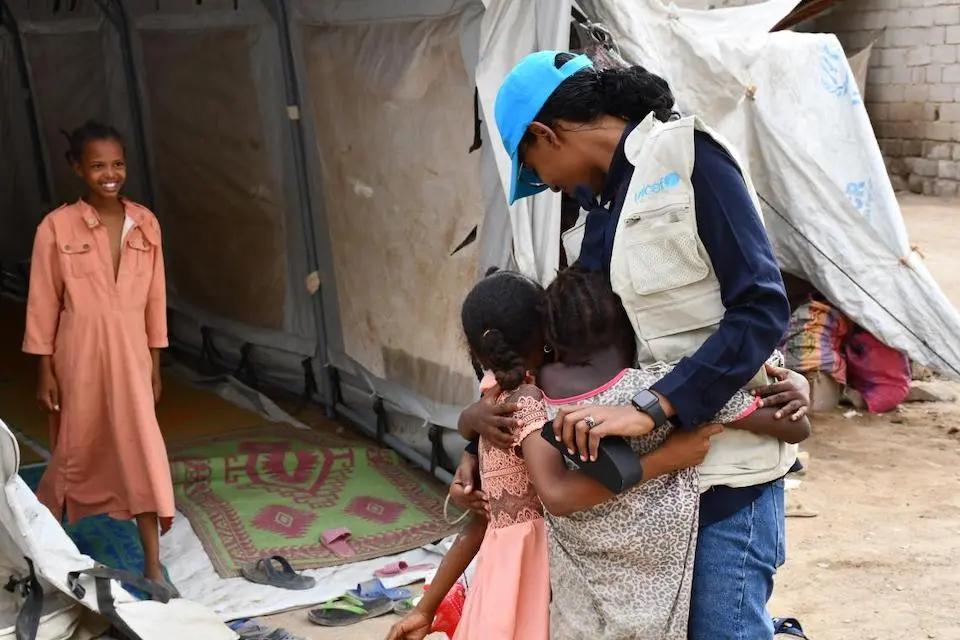 Rasha Obaid, UNICEF Education Officer, hugs two children receiving learning support at the UNICEF Child-Friendly Space in Port Sudan.
