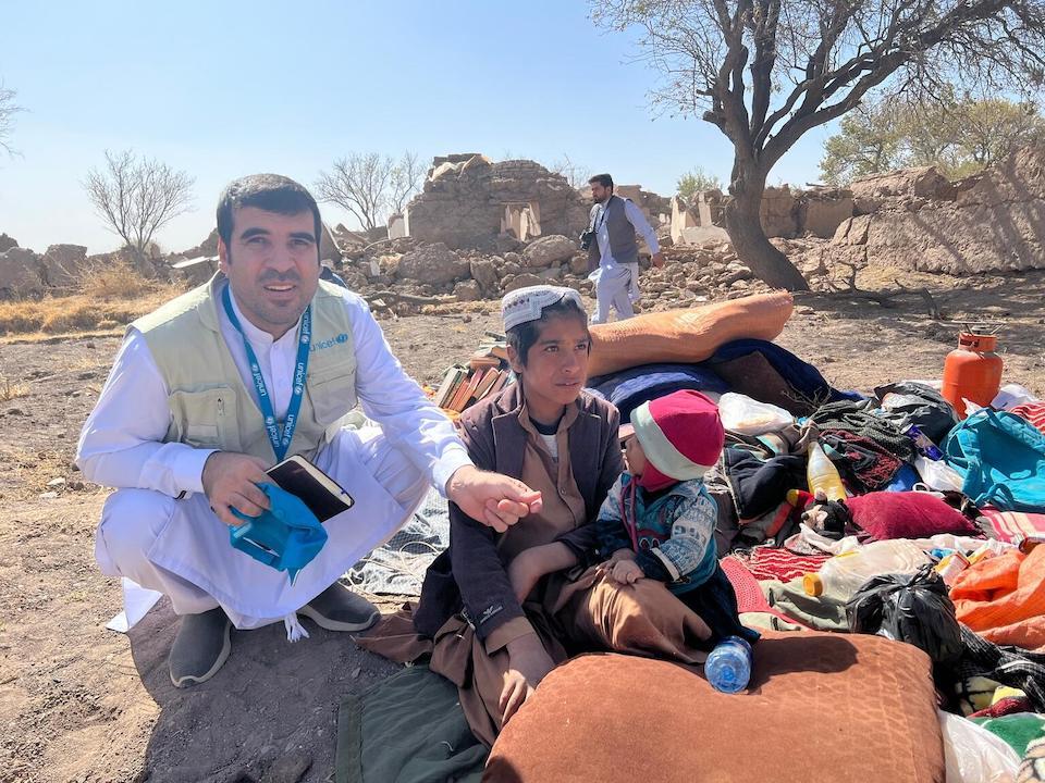 On Oct. 8, 2023, in Zanda Jan district, Herat Province, UNICEF Education Officer Nasir Ahmad Malekzadeh speaks with 13-year-old Hekmatullah and his 9-year-old sister, Khadija, after the earthquake in western Afghanistan. 