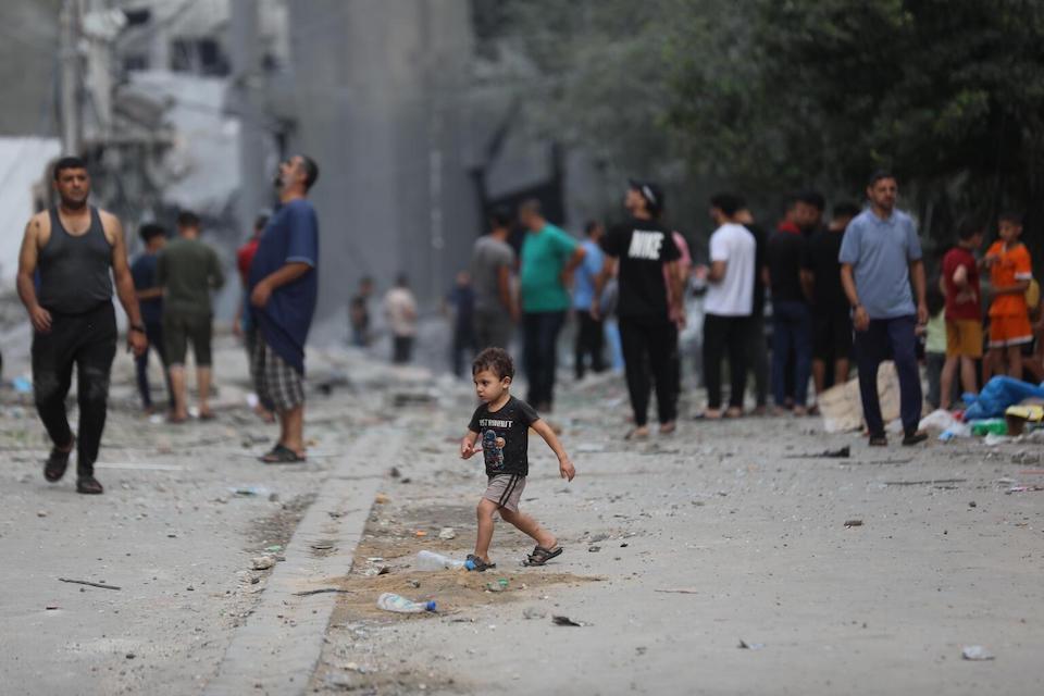 A Palestinian child in the street amidst the wreckage of homes destroyed by airstrikes in Al Shati Refugee Camp in the Gaza Strip.