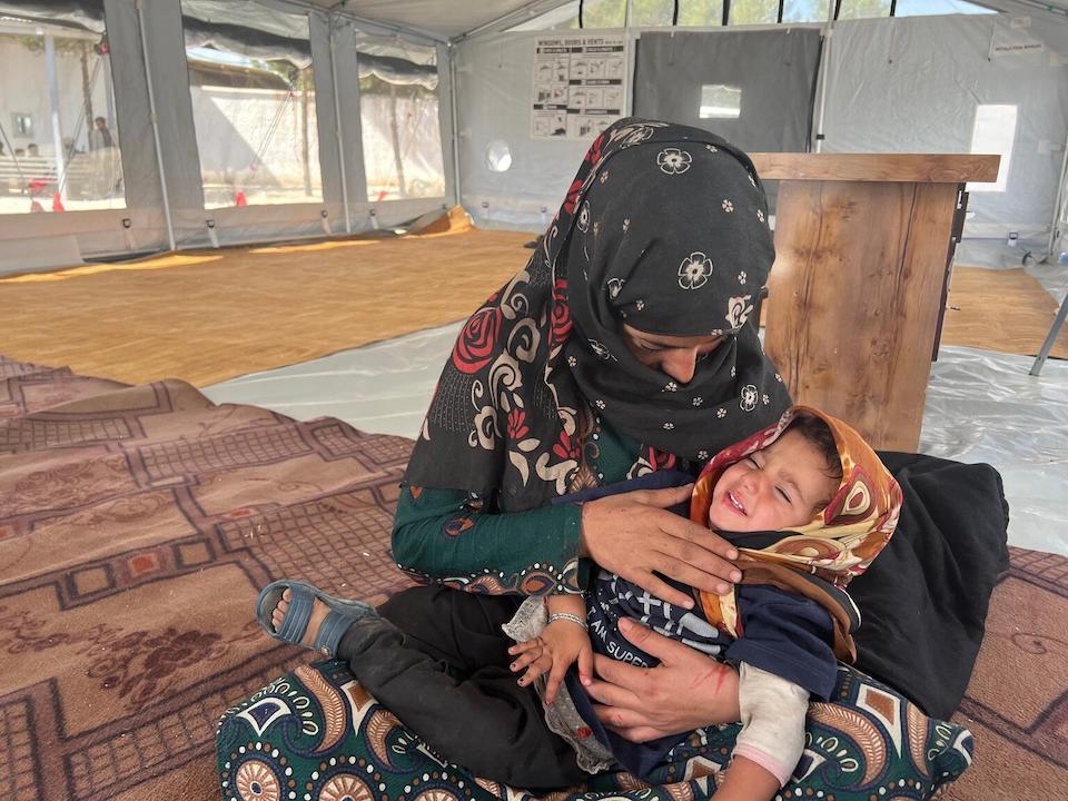 On Oct. 10, 2023, 21-year-old Asifa comforts her 2-year-old daughter, Asra, inside a temporary shelter at a UNICEF supported transit center in Herat city, Afghanistan.