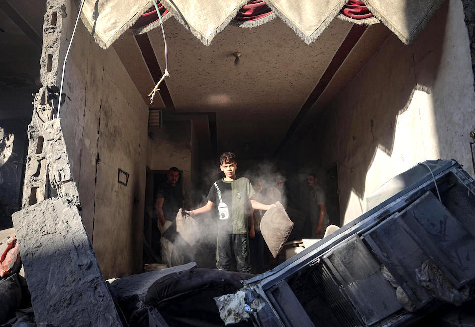Ahmad, 9, stands in the rubble of his house destroyed by an aerial bombardment in Rafah city, due to the continued hostilities in the Gaza Strip