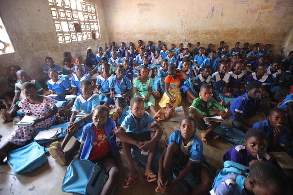 In October 2023, students sit on the floor in a crowded classroom at Kalima Primary School in Malawi. 