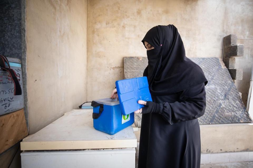 UNICEF-supported Community Health Worker with cold box for carrying vaccines in Pakistan.