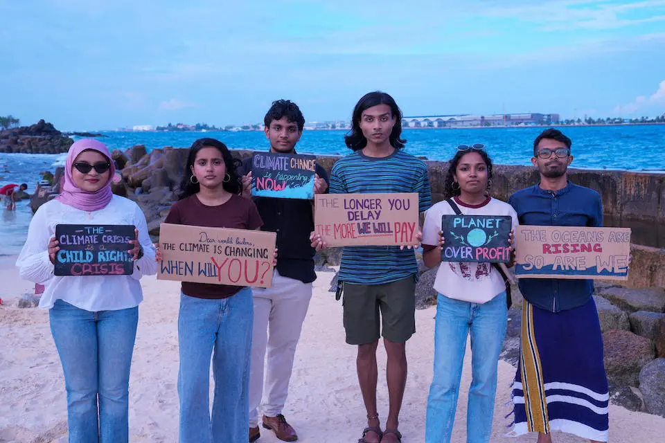 Six youth participants in a mock negotiating session organized by UNICEF in the lead up to a youth climate conference stand on an artificial beach in Malé, Maldives. Youth agency and participation in climate solutions are considered critical in the country’s fight against climate change.