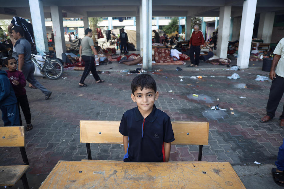 Ahmad, 10, sits at a school desk in one of the shelters in Khan Younis City in the Gaza Strip.