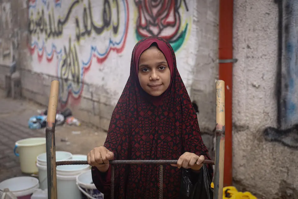 On Nov. 3, 2023 in the Gaza Strip, Mariam uses a cart to fetch drinking water for her family.