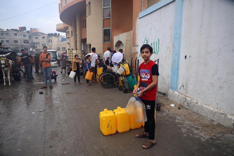 Ahmad, 14, waits to fill water containers in Rafah City, Gaza on Nov. 3, 2023.