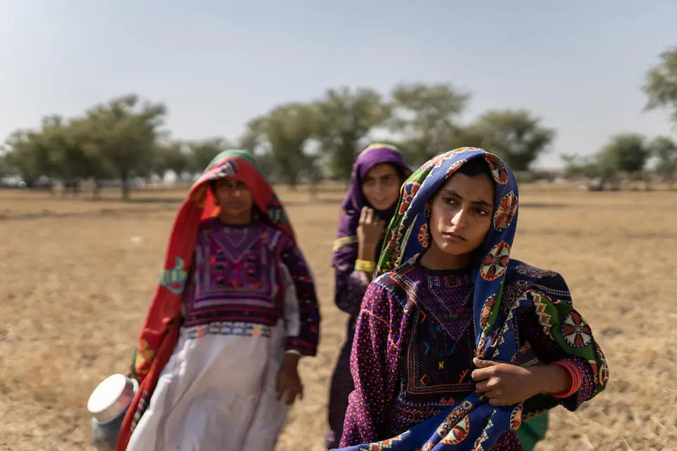 Saima, 10, right, joins her mother and sister on a 45-minute walk to find safe water in Allah Abad, Jampur, South Punjab, Pakistan.