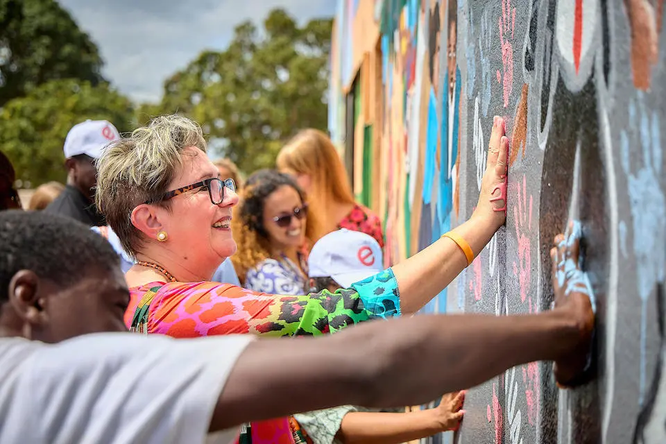 Zonta International President Ute Scholz joins community members to paint a mural in Monapo District, Nampula Province, Mozambique on Sept. 21, 2023.