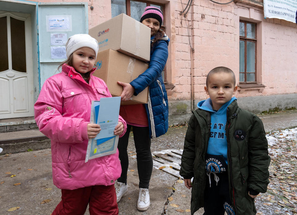 A family in Marhanets, Dnipropetrovsk region, Ukraine, receives boxes of warm clothing and other supplies from UNICEF as part of a winter support program. 