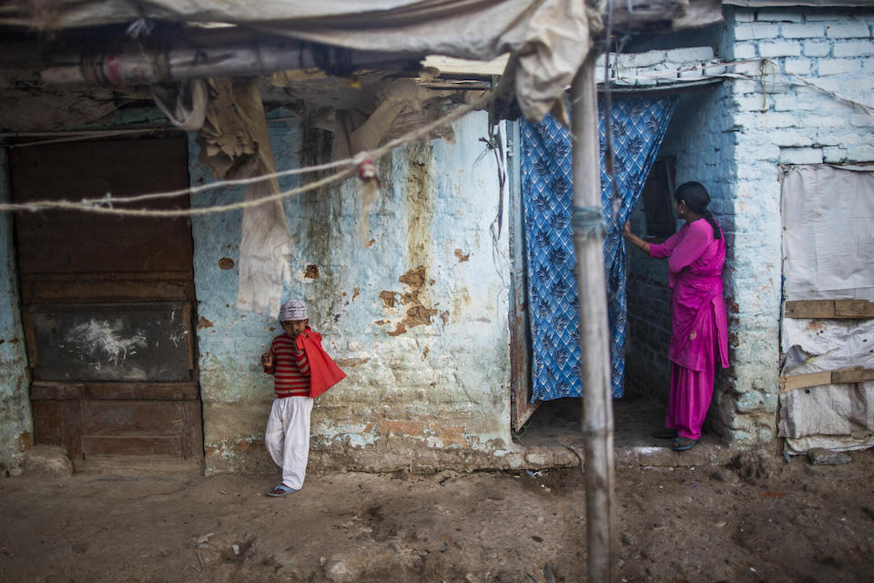 A mother and child outside their home in a slum area of Ali Nagar City, Ranchi district, Jharkhand state, India.