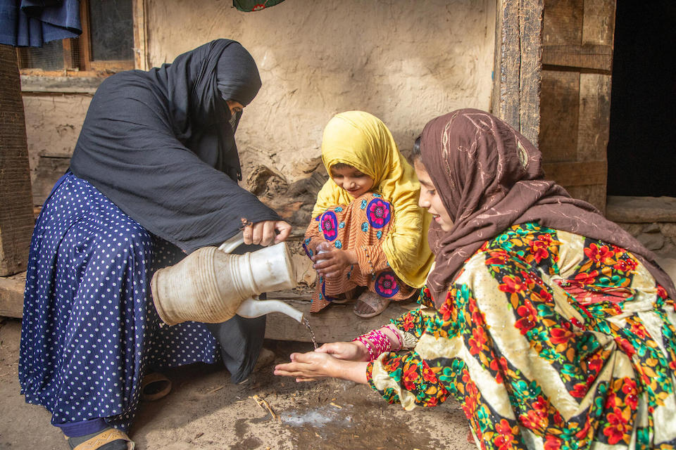 On Nov. 28, 2023, Saeed Khanum pours water for her 5-year-old daughter Farina and 10-year-old daughter Farzana to wash their hands in Parun district, Nuristan province, Afghanistan.