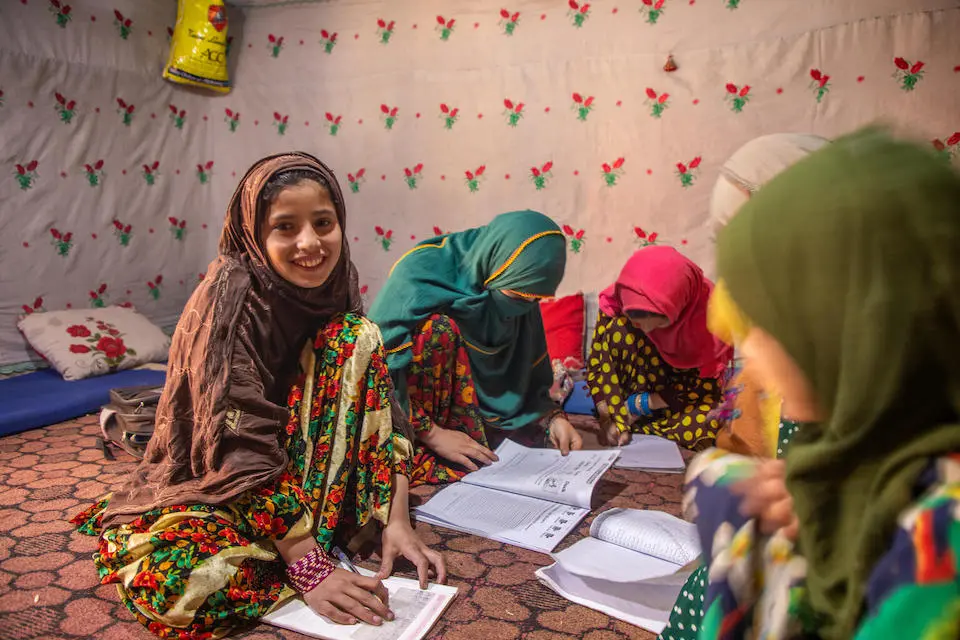 On Nov. 28, 2023, 10-year-old Farzana and her five sisters work on their school lessons inside the family's one-room home in Parun district, Nuristan province, Afghanistan.