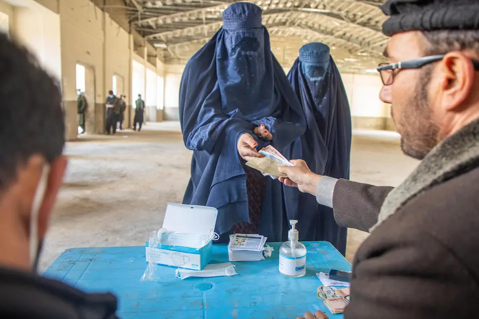 In Nuristan province, Afghanistan, women line up to receive cash assistance from UNICEF to help their family afford to send their daughters to school.