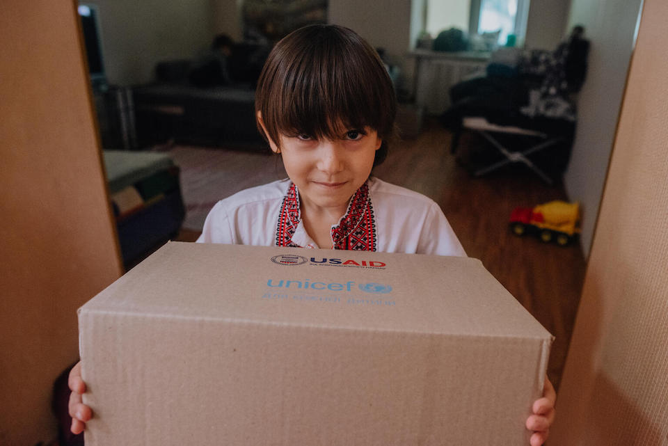In Odesa, Ukraine, Ihnat, 7, holds a winter clothes kit provided by UNICEF.