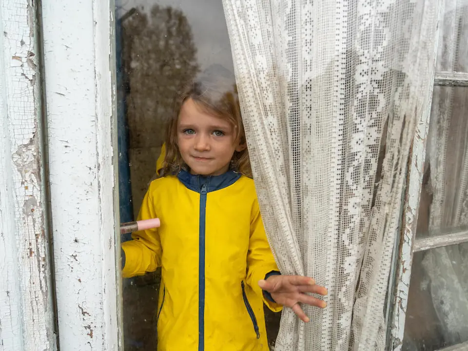 Maria, 4, looks through the window of her house in Izium, Kharkivska oblast, Ukraine., .