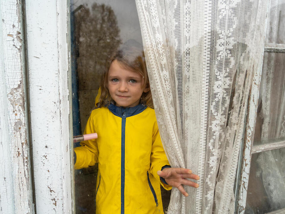 Maria, 4, looks through the window of her house in Izium, Kharkivska oblast, Ukraine., .