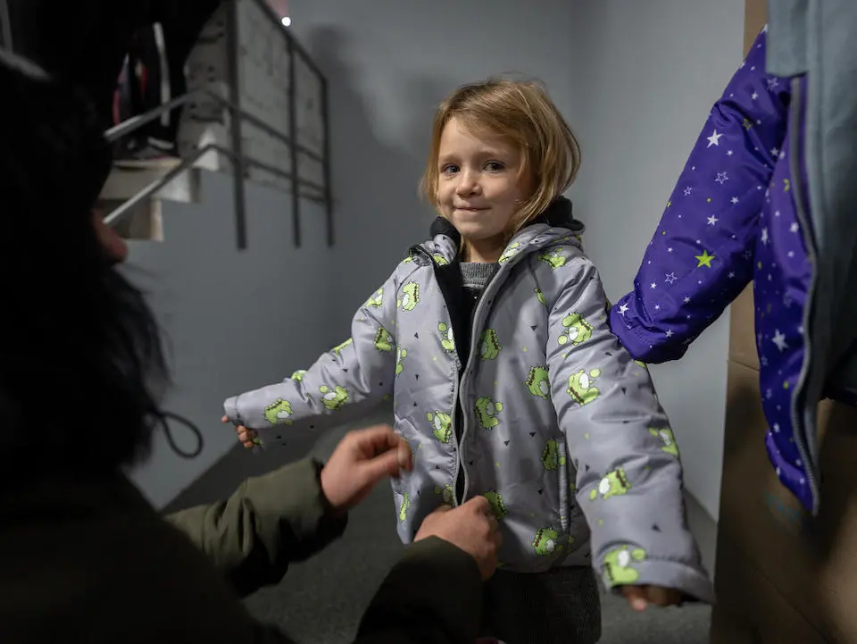 In Izium, Kharkivska oblast, Ukraine, 4-year-old Maria tries on a winter jacket provided by UNICEF.