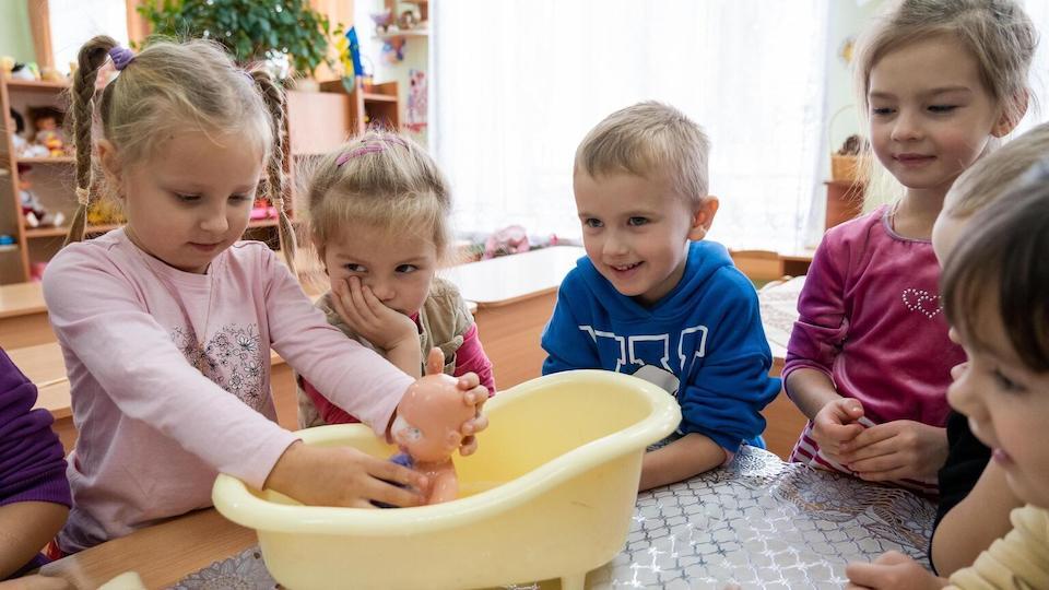 Children bathe a doll at a UNICEF-supported school in Vasylkiv, Ukraine, on Nov. 22, 2023.