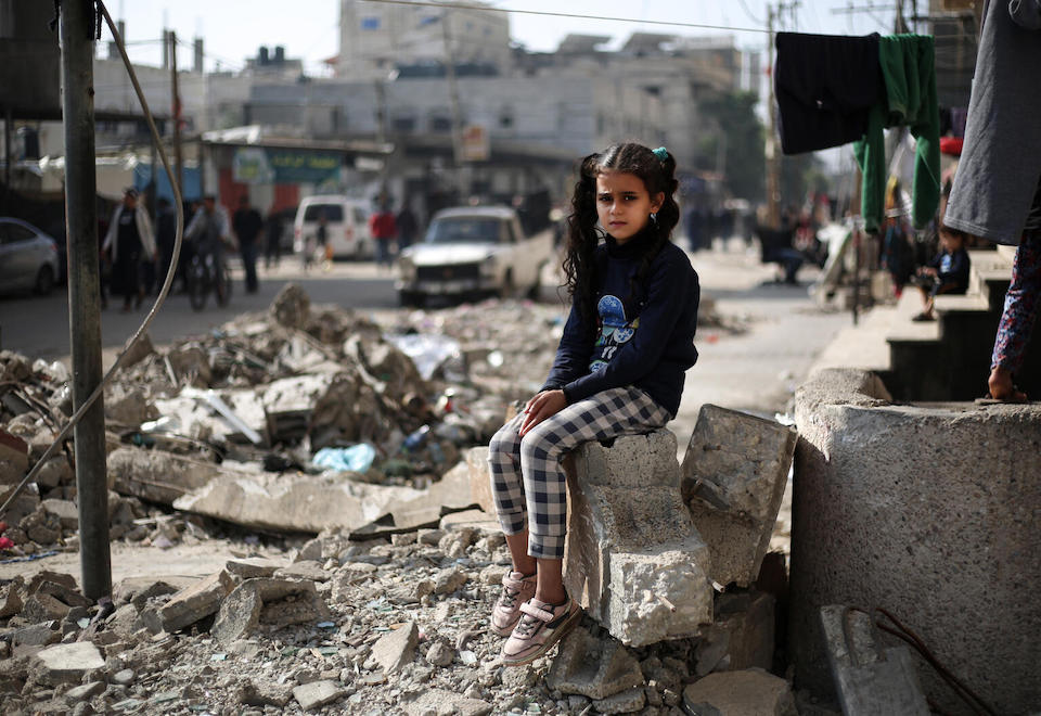 Maha, an 11-year-old, sits on the ruins of a house in Rafah, southern Gaza Strip.
